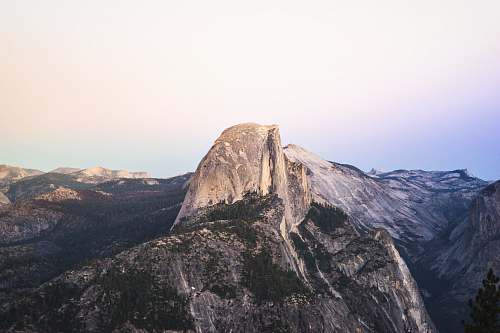 mountain range gray and brown rock formation under blue sky photography nature